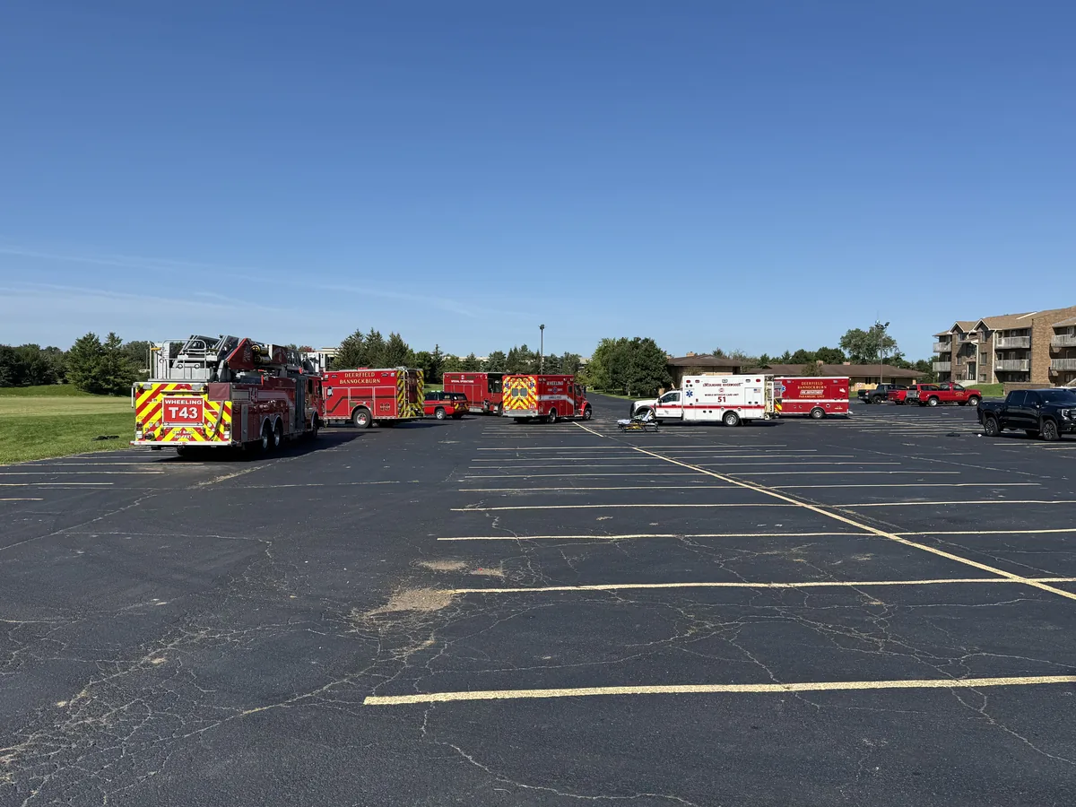 Fire and EMS apparatus from several area departments staged across a parking lot during a multi-agency mass-casualty drill.